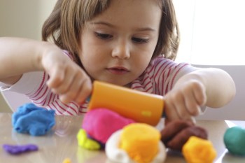 Little girl creating toys from play dough